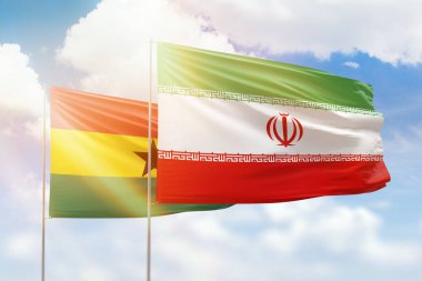 Sunny blue sky and flags of iran and ghana