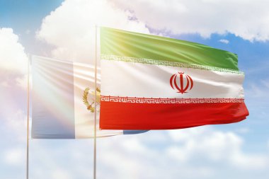 Sunny blue sky and flags of iran and guatemala
