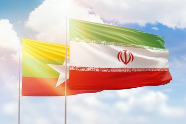 Sunny blue sky and flags of iran and myanmar