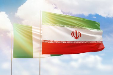 Sunny blue sky and flags of iran and nigeria