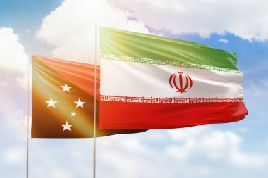 Sunny blue sky and flags of iran and papua new guinea