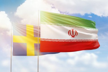 Sunny blue sky and flags of iran and sweden