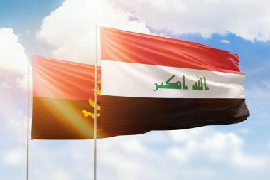 Sunny blue sky and flags of iraq and angola