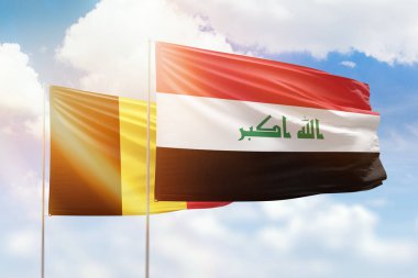 Sunny blue sky and flags of iraq and belgium