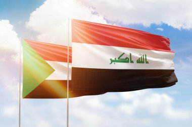 Sunny blue sky and flags of iraq and sudan