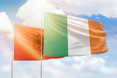 Sunny blue sky and flags of ireland and albania