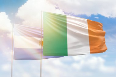 Sunny blue sky and flags of ireland and argentina