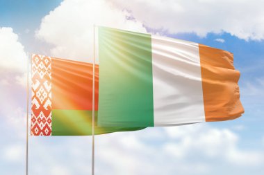 Sunny blue sky and flags of ireland and belarus