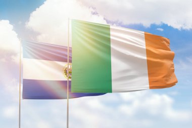 Sunny blue sky and flags of ireland and el salvador