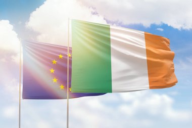 Sunny blue sky and flags of ireland and european union