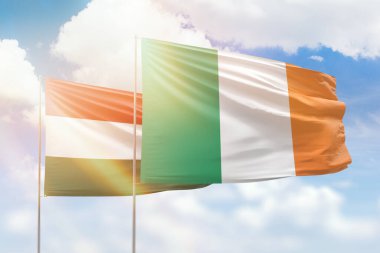 Sunny blue sky and flags of ireland and hungary