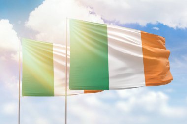 Sunny blue sky and flags of ireland and ireland