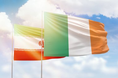 Sunny blue sky and flags of ireland and iran