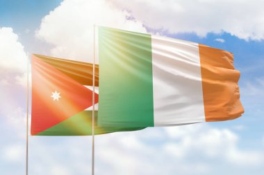 Sunny blue sky and flags of ireland and jordan