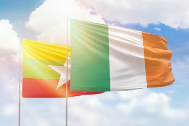 Sunny blue sky and flags of ireland and myanmar