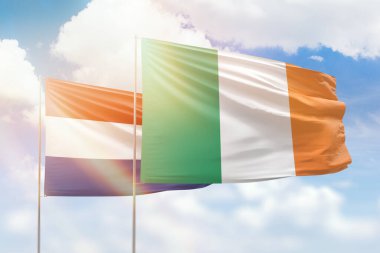 Sunny blue sky and flags of ireland and netherlands