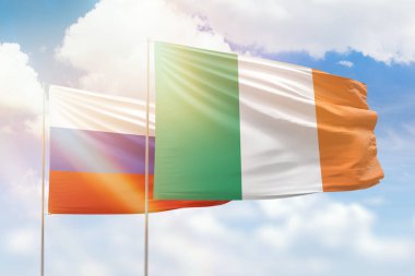 Sunny blue sky and flags of ireland and russia