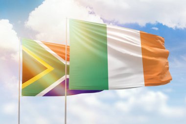 Sunny blue sky and flags of ireland and south africa