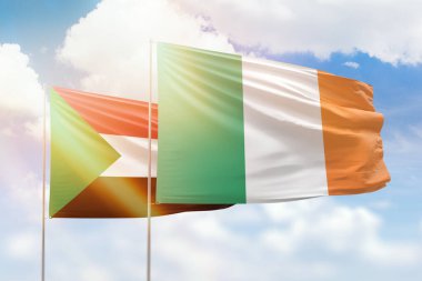 Sunny blue sky and flags of ireland and sudan