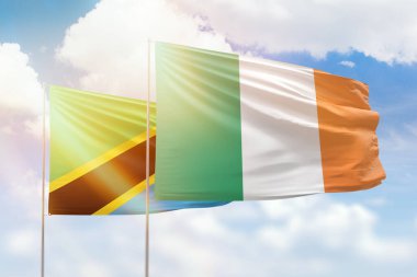 Sunny blue sky and flags of ireland and tanzania