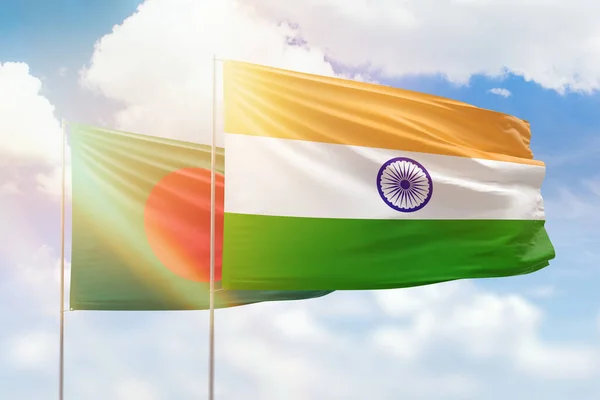 Sunny blue sky and flags of india and bangladesh