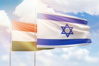 Sunny blue sky and flags of israel and hungary