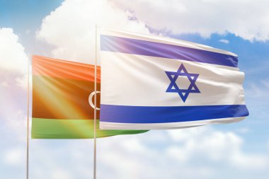 Sunny blue sky and flags of israel and libya