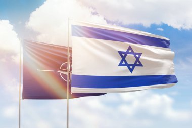 Sunny blue sky and flags of israel and nato