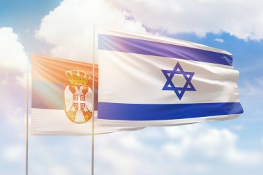 Sunny blue sky and flags of israel and serbia