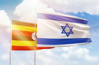Sunny blue sky and flags of israel and uganda