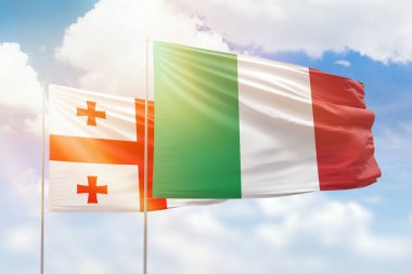 Sunny blue sky and flags of italy and georgia