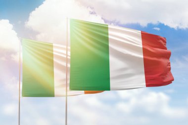 Sunny blue sky and flags of italy and ireland