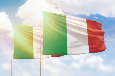 Sunny blue sky and flags of italy and italy