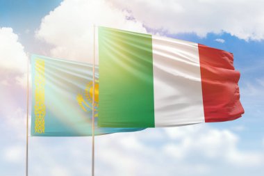 Sunny blue sky and flags of italy and kazakhstan