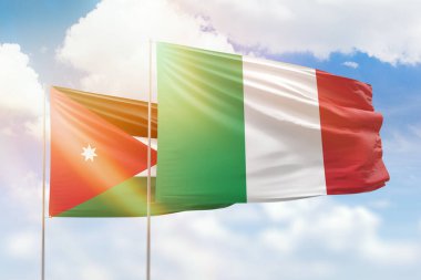 Sunny blue sky and flags of italy and jordan
