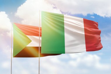 Sunny blue sky and flags of italy and sudan