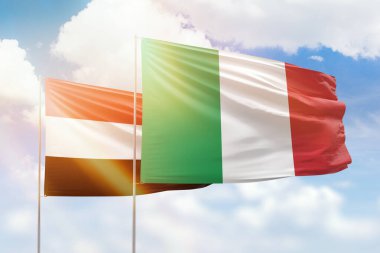 Sunny blue sky and flags of italy and yemen