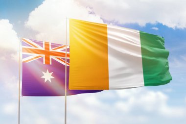 Sunny blue sky and flags of ivory coast and australia
