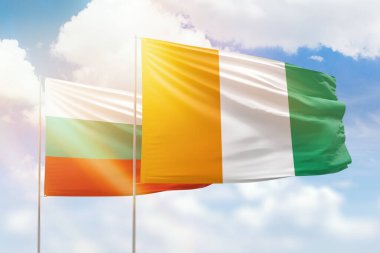 Sunny blue sky and flags of ivory coast and bulgaria