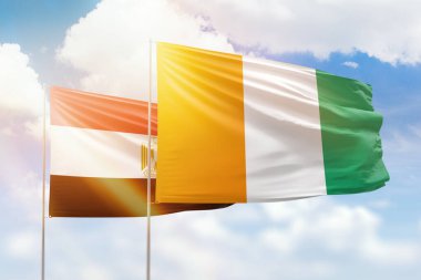Sunny blue sky and flags of ivory coast and egypt