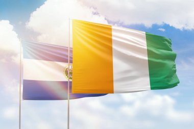 Sunny blue sky and flags of ivory coast and el salvador