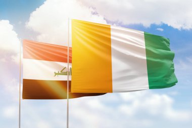 Sunny blue sky and flags of ivory coast and iraq