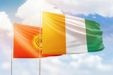 Sunny blue sky and flags of ivory coast and kyrgyzstan