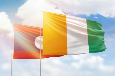 Sunny blue sky and flags of ivory coast and laos