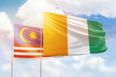 Sunny blue sky and flags of ivory coast and malaysia