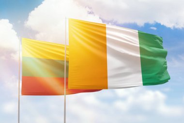 Sunny blue sky and flags of ivory coast and lithuania