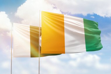 Sunny blue sky and flags of ivory coast and pakistan