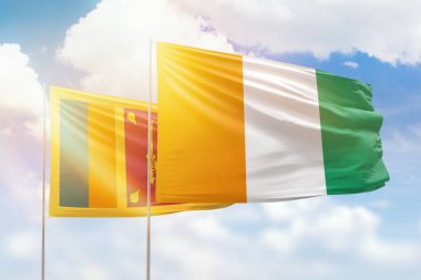 Sunny blue sky and flags of ivory coast and sri lanka