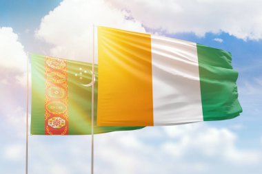 Sunny blue sky and flags of ivory coast and turkmenistan