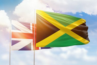 Sunny blue sky and flags of jamaica and great britain